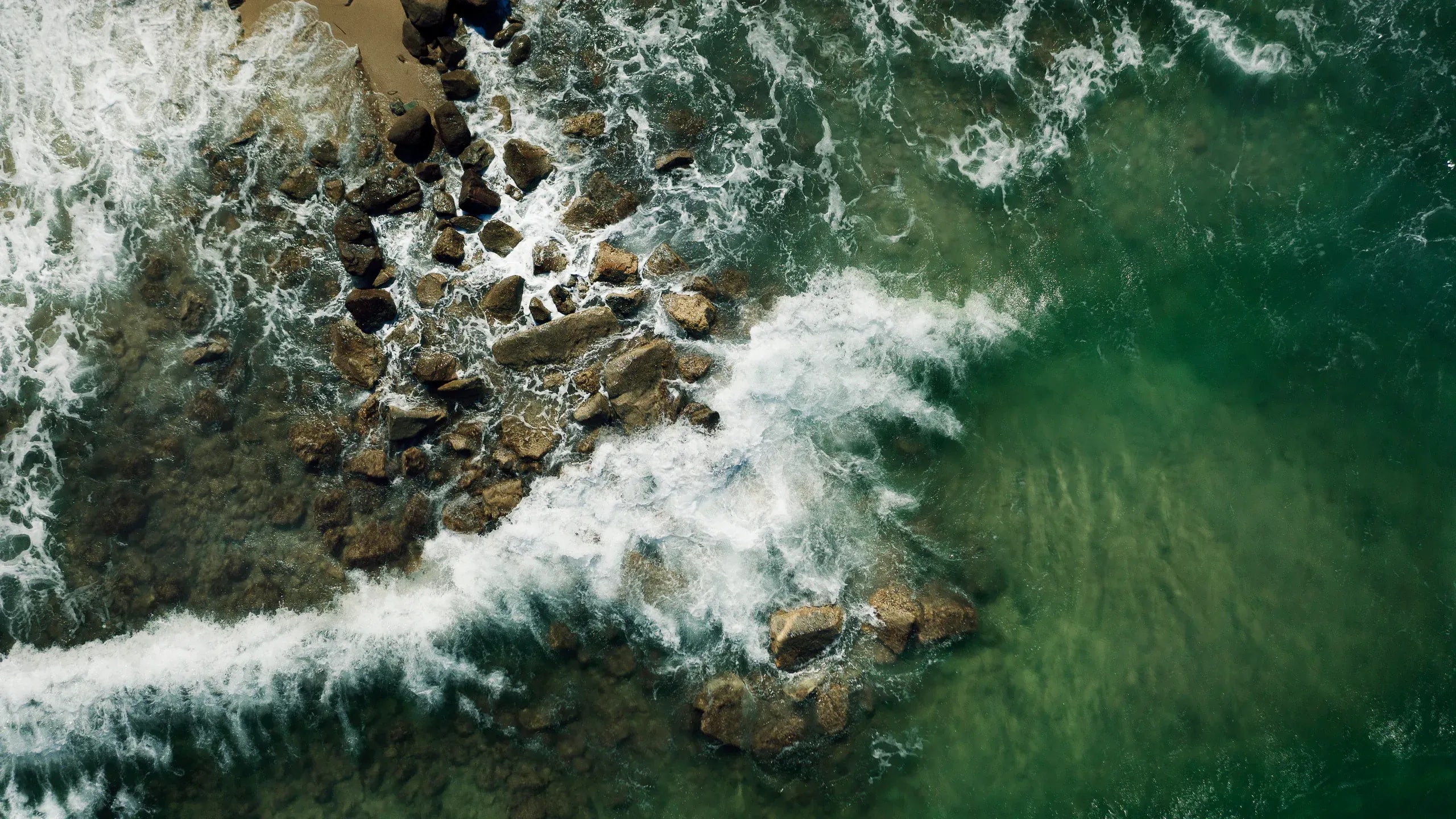 Aerial view of surf breaking over rocks on the Mykonos coast