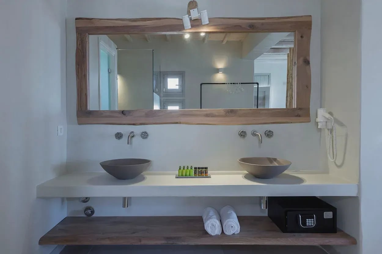 Bathroom with two stone basins beneath a wide timber-framed mirror