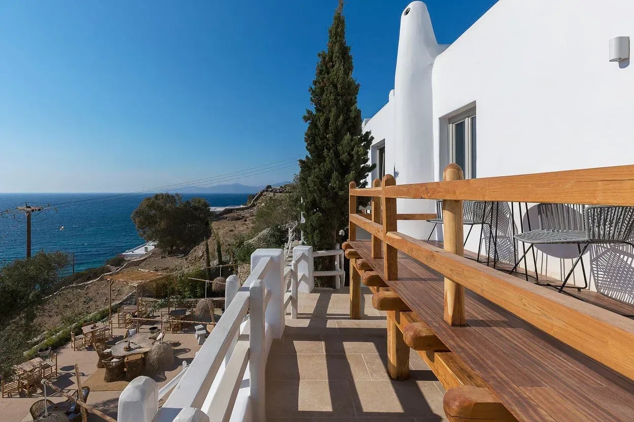 Timber-railed walkway along the suite balcony above the sea
